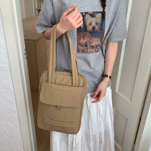 Detailed side view of khaki quilted tote bag with front pocket and thick shoulder straps