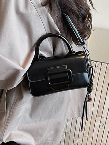 Chic black glossy handbag with oversized square buckle and decorative metal charm