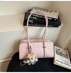 Pink minimalist handbag featuring a cute plush bear charm and metallic ring detail