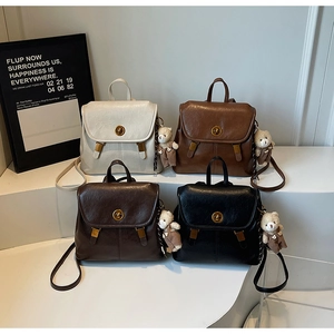 Detailed display of vintage PU leather backpacks in beige, brown, and black with bear charms