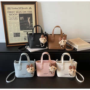 Detailed view of minimalist bucket bags in five colors with teddy bear charms