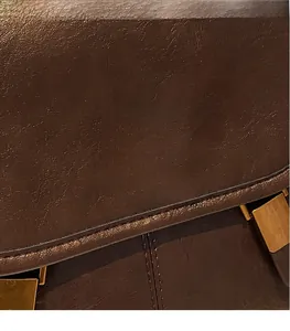 Close-up of retro dark brown leather backpack with gold metal twist lock and fine stitching