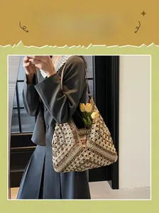 Detail of hand-woven straw tote bag with intricate floral patterns and large capacity