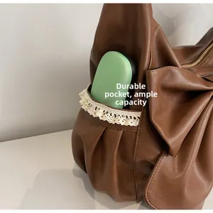 Detail shot of the side lace-up pocket on a vintage brown faux leather bow shoulder bag