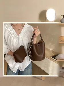 Détails d'un sac seau en cuir marron foncé avec pochette intérieure et pendentif chic