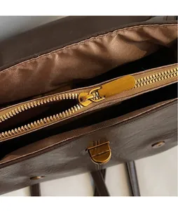 Macro view of brown vintage backpack featuring gold metal zipper and twist lock detail
