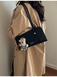 Chic black shoulder bag with silver orb hardware and a cute blue bear plush pendant