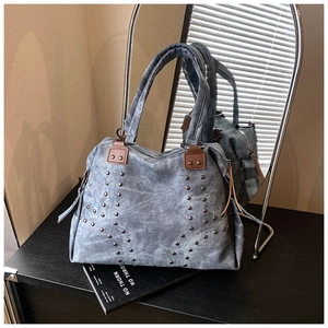 Détail de ce sac fourre-tout gris rétro avec des rivets métalliques en étoile sur le devant