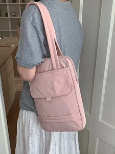 Pink quilted nylon crossbody bag with wide shoulder strap for laptop and daily use