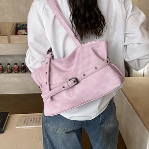 Gros plan du sac hobo rose avec ceintures à boucles rétro et détails d'oeillets