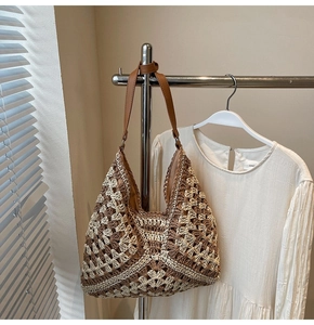 Detail of hand-woven crochet tote bag with dark brown leather straps on a hanger