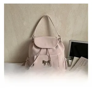 Détail du sac à dos rose montrant la boucle noeud, le cordon et la texture en daim