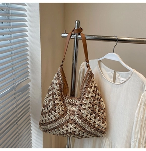 Detail of bohemian crochet tote with floral pattern and brown leather shoulder strap