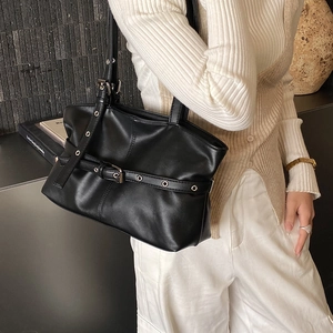 Détail du sac bandoulière plissé noir vintage avec œillets argentés et boucle décorative