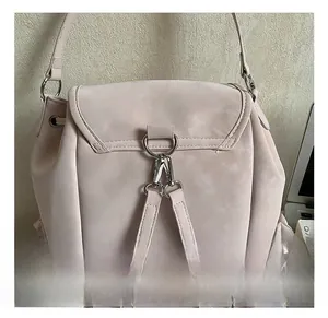 Détail des crochets en métal argenté et anneaux en D sur un sac à dos rose mat