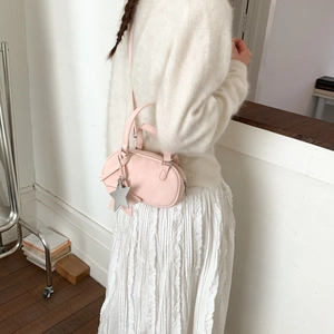 Pink retro Boston pillow bag with star pendant shown in a stylish daily outfit pose