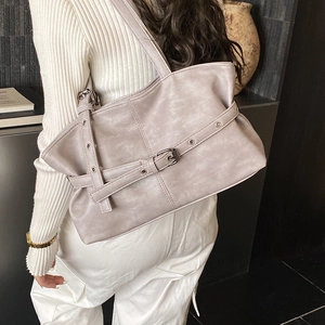 Détail du sac fourre-tout plissé gris-violet avec boucle décorative sur un mannequin