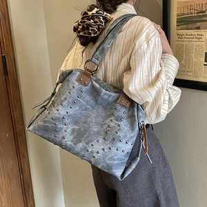 Détail du sac cabas vintage avec clous argentés, texture délavée et anneaux en métal