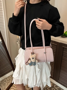 Pale pink rectangular handbag with a teddy bear charm and Fashion & Bags text on the front