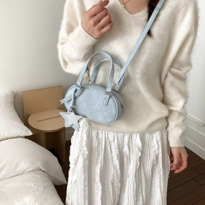 Detail of light blue Boston bag with leather star charm and adjustable shoulder strap