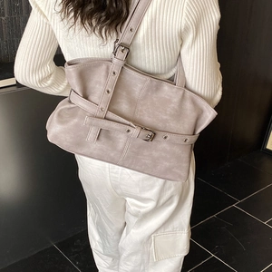 Vue détaillée du grand sac cabas gris avec lanières en cuir et boucles métalliques réglables