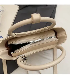 Vue détaillée de la fermeture éclair en métal argenté fluide du sac seau couleur crème