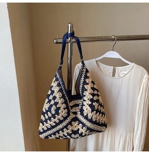 Detailed close-up of woven tote bag with blue geometric patterns and leather strap