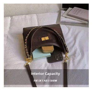 Internal capacity of the dark brown retro dumpling bag showing phone and cosmetics