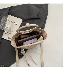 Vue intérieure du sac seau beige montrant l'espace pour téléphone, rouge à lèvres et cartes