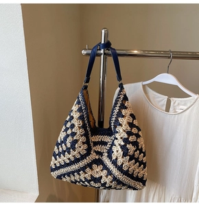 Detail of hand-woven retro geometric pattern on a navy and beige beach tote bag