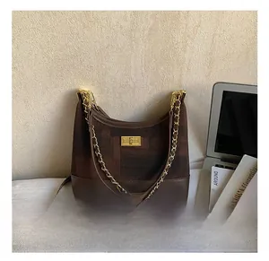 Detail shot of vintage dark brown patterned hobo bag with gold chain and metal lock closure