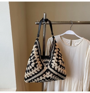Detailed view of large woven tote bag with bicolor crochet patterns and black leather strap