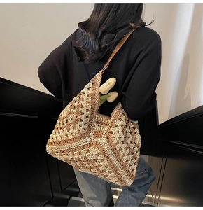 Detail of hand-crocheted hobo bag with geometric patterns and brown leather strap