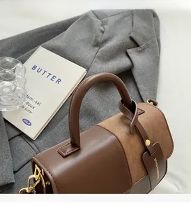 Close-up of brown patchwork handbag featuring smooth leather and textured fabric detail