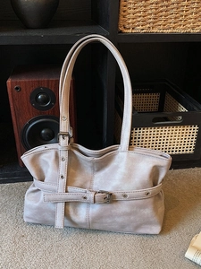 Sac fourre-tout rétro gris clair avec boucles métalliques sur fond d'étagère
