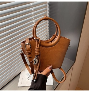 Détail du sac seau marron avec embossage NO FILTER et poignée ronde métallique chic