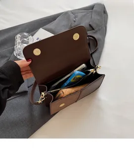 Detail view of the spacious inner compartments of this brown faux leather crossbody bag