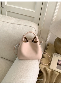 Detailed macro view of the light pink bucket bag with leather texture and silver hardware