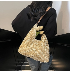 Detail of hand-woven beige tote bag with intricate crochet texture and shoulder strap
