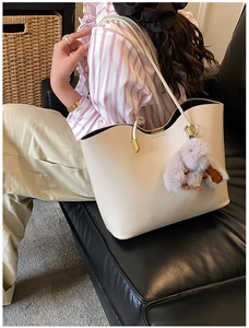 Détail du grand sac cabas crème avec bords ondulés et breloque lapin en peluche doux