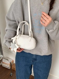 White leather Boston barrel bag with detachable strap and star charm for women