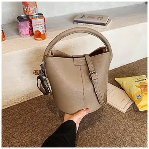 Détails du sac seau kaki en cuir grainé avec accessoire foulard à motif léopard élégant
