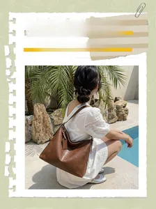 Photo en extérieur d'un grand sac bandoulière marron avec détails en cuir texturé
