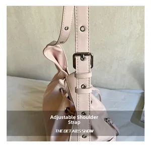 Detail of adjustable pink leather shoulder strap with silver metal buckle and eyelets