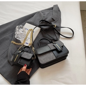 Detail view of two-piece color-block handbag set in black and grey matte leather texture