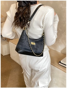 Detail of vintage dumpling shoulder bag with dark grey jacquard and golden chain accent