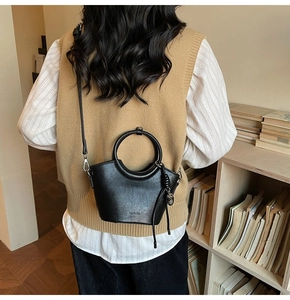 Détail du petit sac seau noir avec embossage NO FILTER et poignée ronde métallique