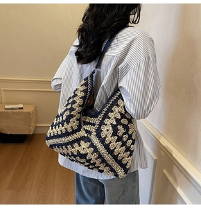 Detailed macro texture of a woven boho tote bag with navy blue and cream floral patterns