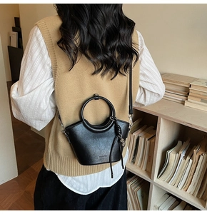 Détail du sac seau noir avec pompon crâne argenté et logo de marque WONDER