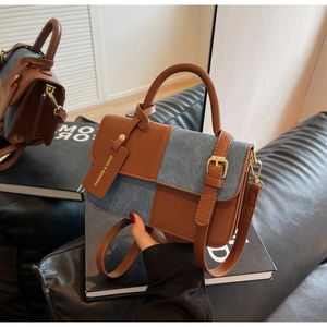 Detail view of mini contrast bag with brown faux leather and blue denim patchwork